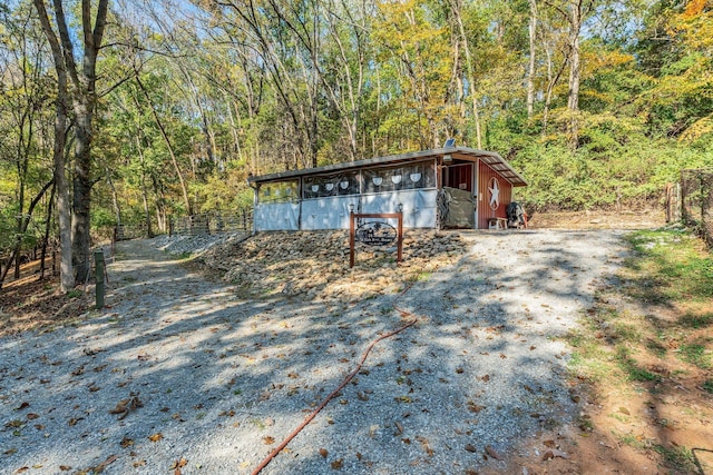 exterior space featuring a view of trees and an outbuilding