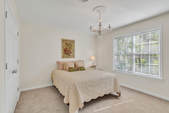 bedroom with light colored carpet, a notable chandelier, and baseboards