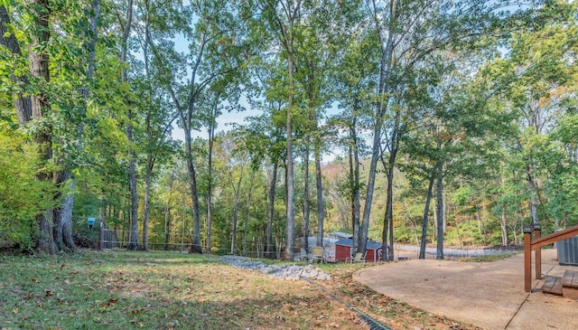 view of yard featuring a forest view and a patio area