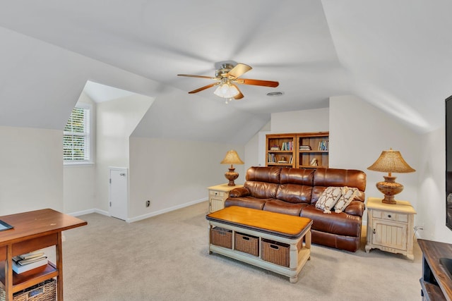 living area featuring baseboards, ceiling fan, lofted ceiling, and light colored carpet