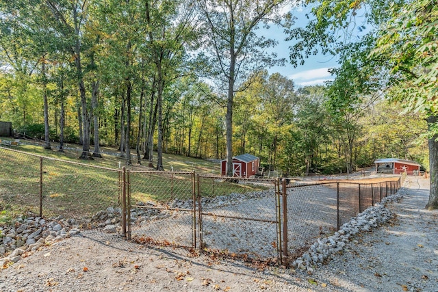 view of yard with an outdoor structure, a storage shed, and fence