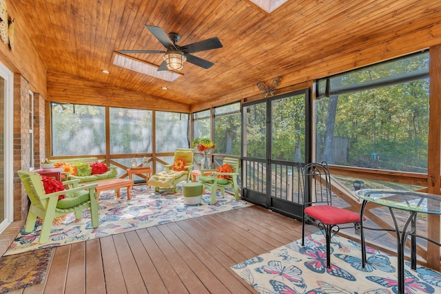 sunroom featuring wooden ceiling, vaulted ceiling with skylight, ceiling fan, and a wealth of natural light