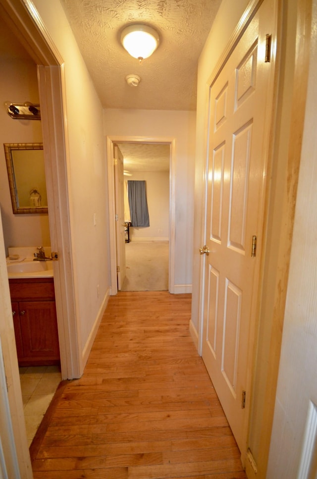 798 Buffalo Valley Rd, Cookeville, TN 38501 - hall featuring a sink, light wood-style floors, baseboards, and a textured ceiling