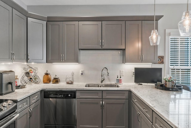 kitchen featuring appliances with stainless steel finishes, a sink, backsplash, and gray cabinetry