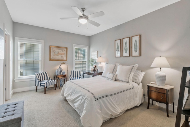 bedroom featuring a ceiling fan, light carpet, and baseboards