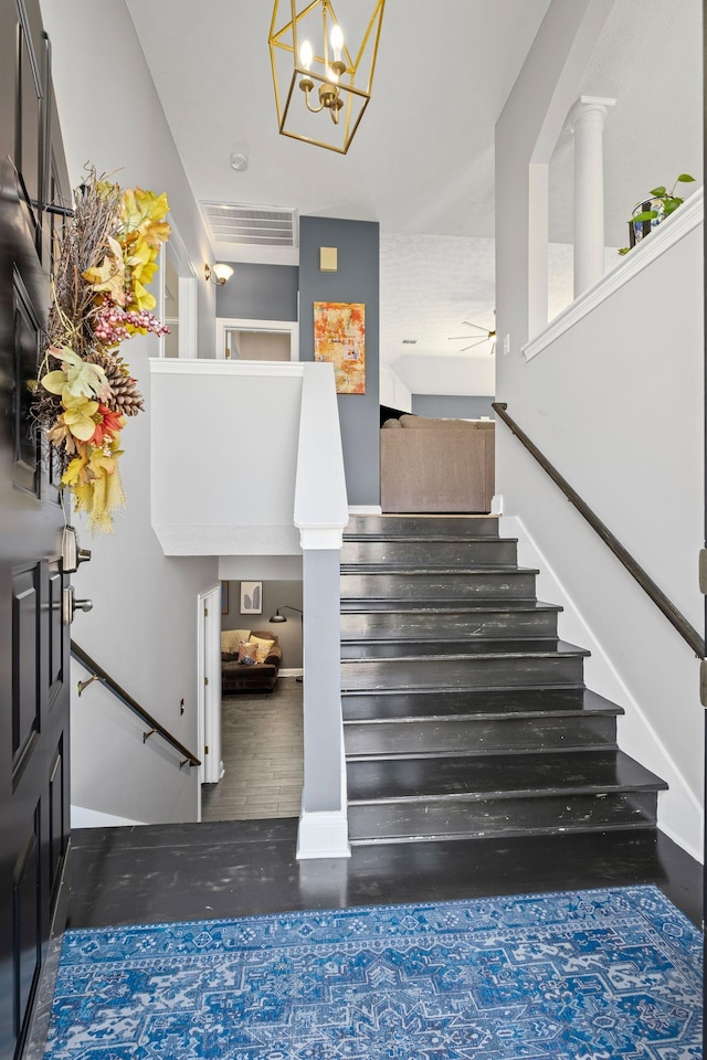 stairs with a ceiling fan, visible vents, baseboards, and wood finished floors