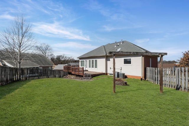 back of house with a fenced backyard, a deck, a shingled roof, and a yard