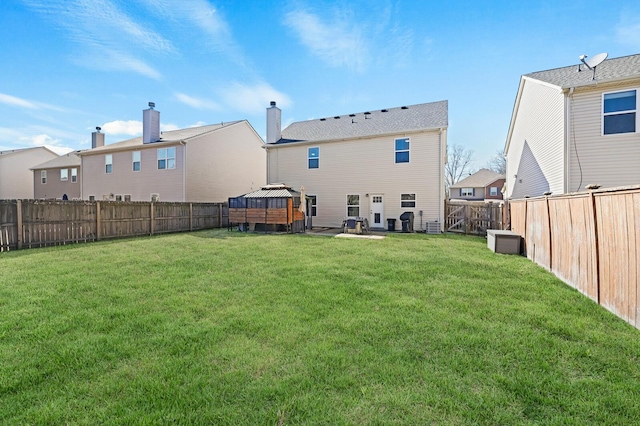 rear view of property with a patio, a fenced backyard, central AC, a gazebo, and a lawn