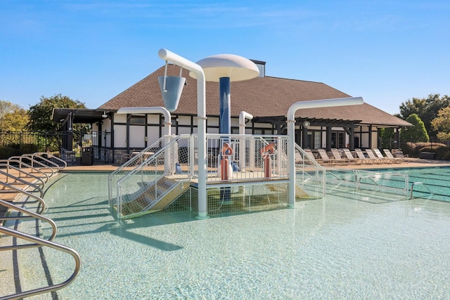 community pool featuring a patio area and a water play area