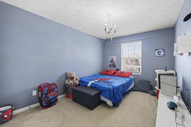 carpeted bedroom featuring baseboards, a textured ceiling, and an inviting chandelier