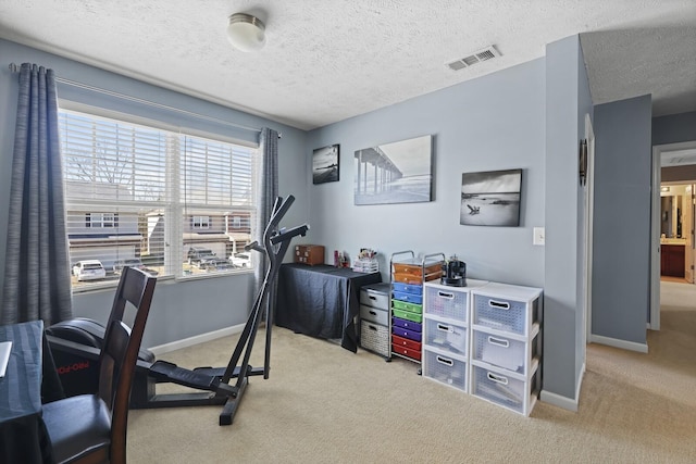 carpeted office featuring visible vents, a textured ceiling, and baseboards