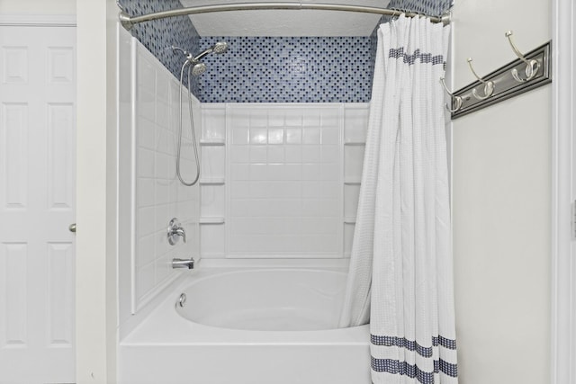 bathroom with a textured ceiling and shower / bath combination with curtain