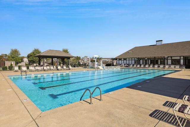 pool featuring a patio area, fence, a water slide, and a gazebo