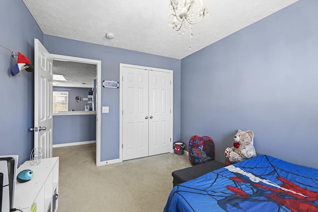 carpeted bedroom with a closet, a textured ceiling, and baseboards