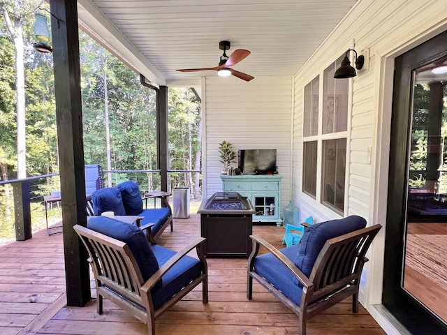 wooden terrace with ceiling fan and an outdoor living space