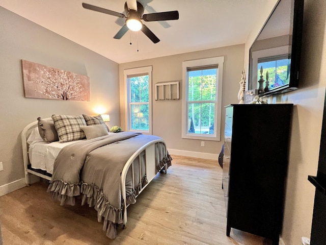 bedroom with baseboards, ceiling fan, and light wood finished floors