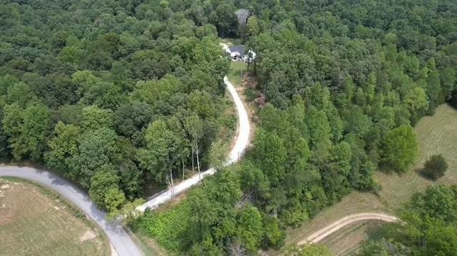 bird's eye view with a wooded view