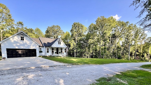 view of front of house with driveway, covered porch, a garage, and a front yard