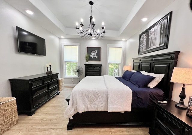 bedroom with recessed lighting, light wood-type flooring, a raised ceiling, and baseboards