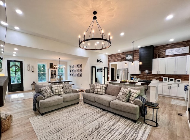 living area with a chandelier, light wood-type flooring, baseboards, and recessed lighting