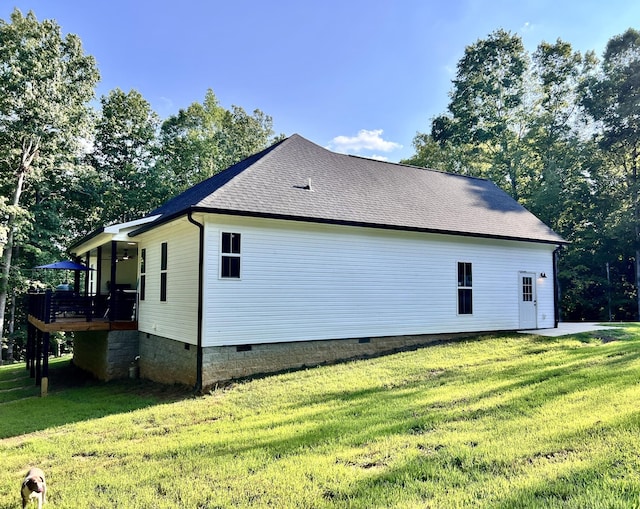 view of side of home with a yard, a shingled roof, and crawl space