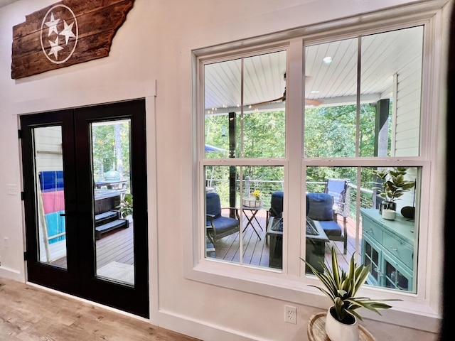 entryway featuring baseboards, wood finished floors, and french doors