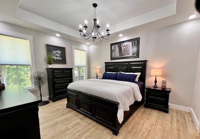 bedroom featuring a tray ceiling and multiple windows