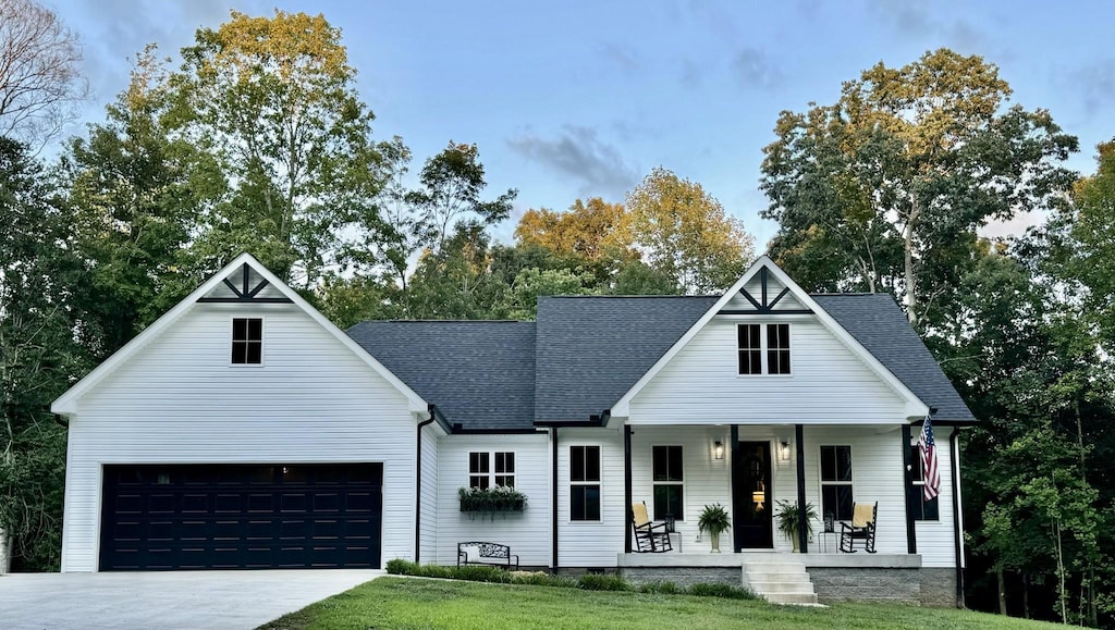 859 Lucas Rd, Dickson, TN 37055 - modern farmhouse featuring a shingled roof, covered porch, an attached garage, driveway, and a front lawn