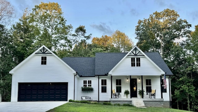 modern farmhouse featuring a shingled roof, covered porch, an attached garage, driveway, and a front lawn