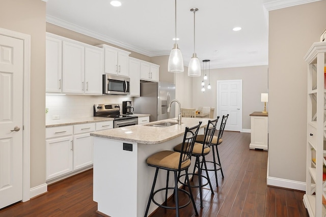 624 Cobert Ln, Franklin, TN 37064 - kitchen featuring appliances with stainless steel finishes, an island with sink, a breakfast bar, white cabinets, and dark wood-type flooring