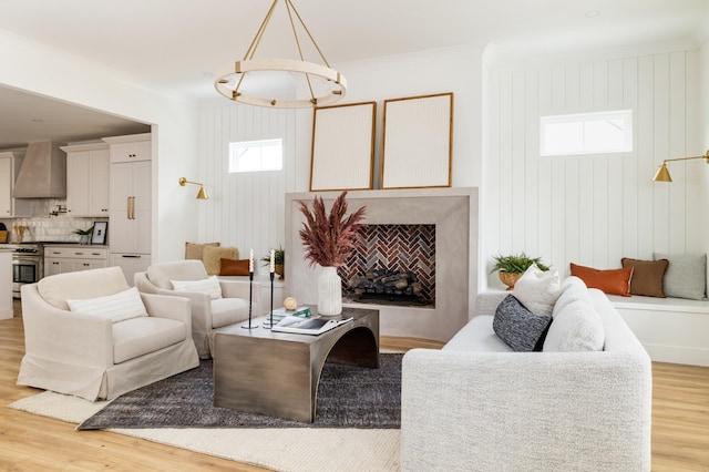 living room featuring light wood-style floors, a fireplace, and ornamental molding