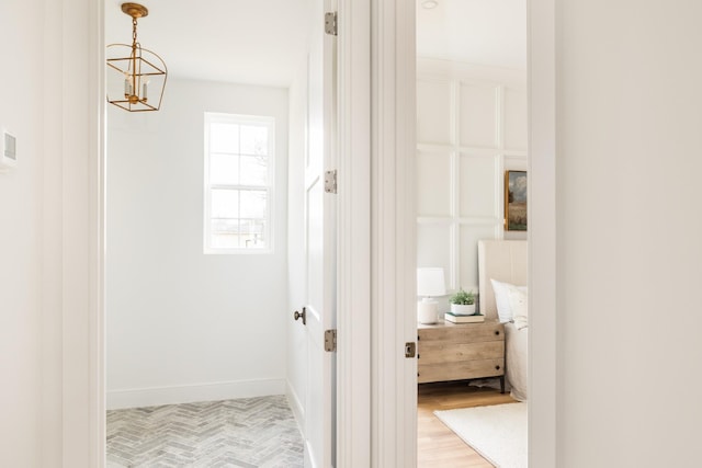 hallway featuring light wood-type flooring and baseboards