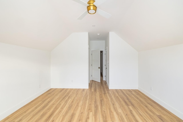 additional living space with light wood-style flooring, baseboards, vaulted ceiling, and a ceiling fan