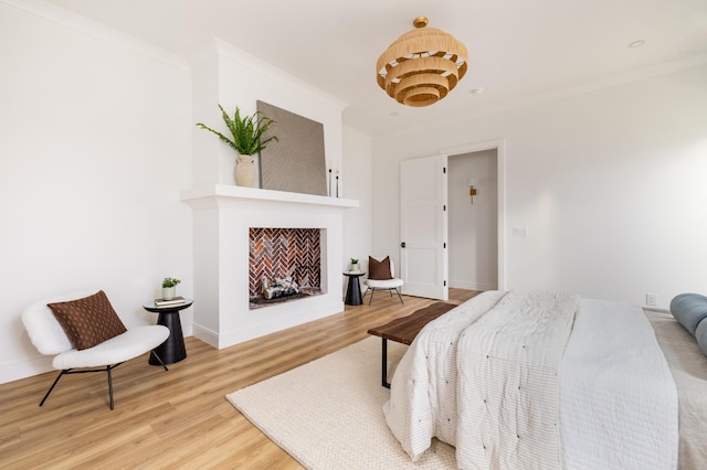 bedroom with ornamental molding, a fireplace, wood finished floors, and baseboards