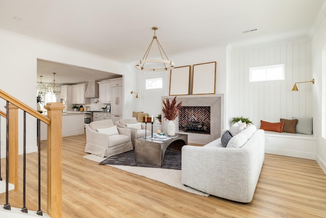 living room featuring stairs, light wood-style flooring, plenty of natural light, and visible vents