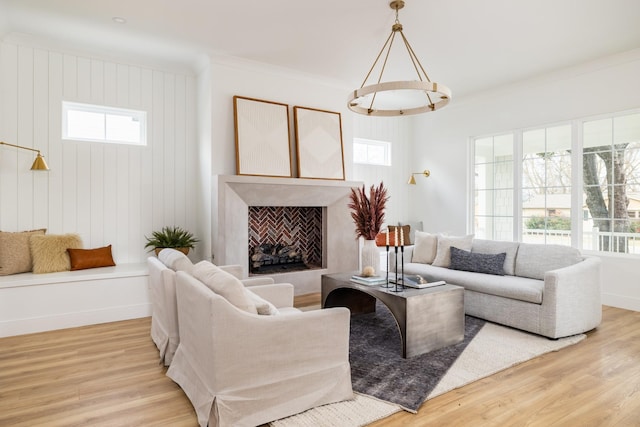 living area featuring light wood-style floors, plenty of natural light, and a premium fireplace