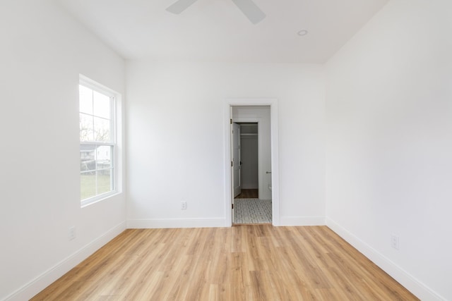 spare room with light wood-style flooring, baseboards, and a ceiling fan