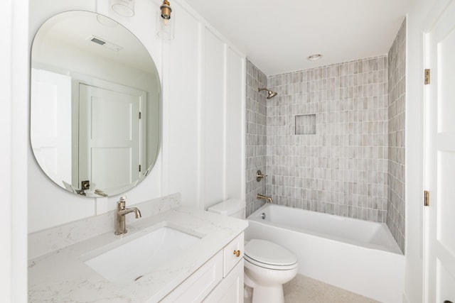 bathroom with toilet, visible vents,  shower combination, and vanity