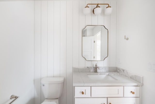 half bathroom featuring vanity and toilet