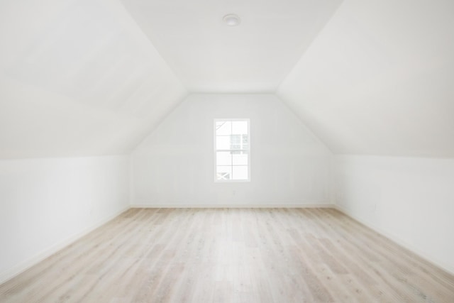 additional living space featuring lofted ceiling and light wood finished floors