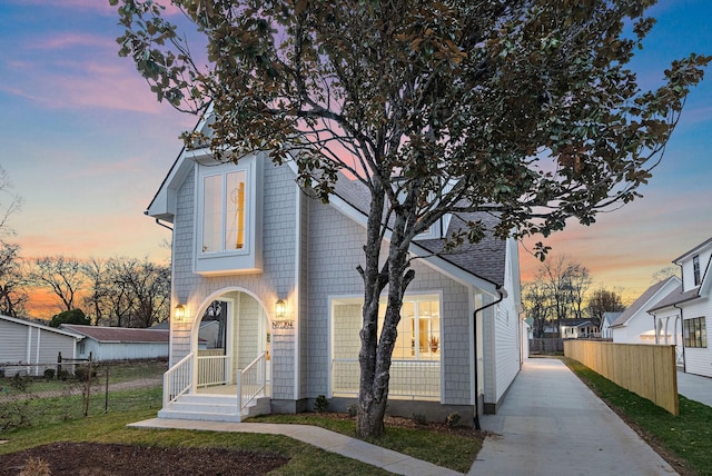 view of front of home featuring a porch and fence