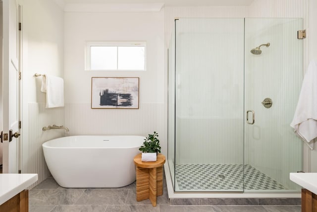 full bathroom featuring a soaking tub, a shower stall, and vanity