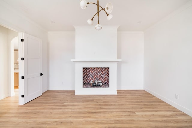 unfurnished living room featuring light wood-style floors, a fireplace, and crown molding