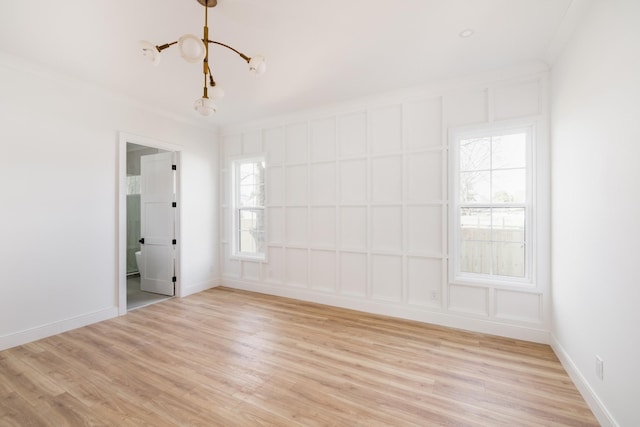 unfurnished room with baseboards, light wood-style flooring, and crown molding