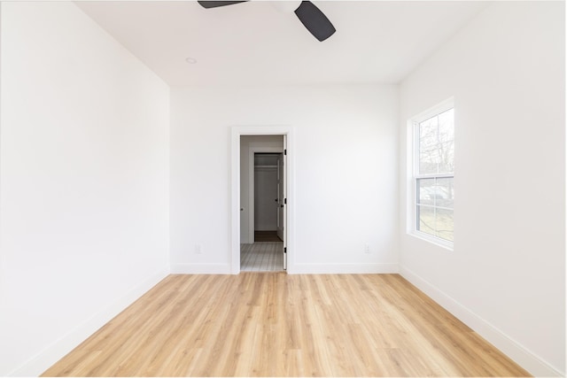 unfurnished room featuring ceiling fan, light wood finished floors, and baseboards