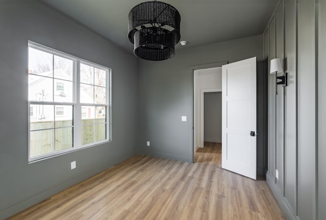 unfurnished room featuring baseboards and light wood finished floors