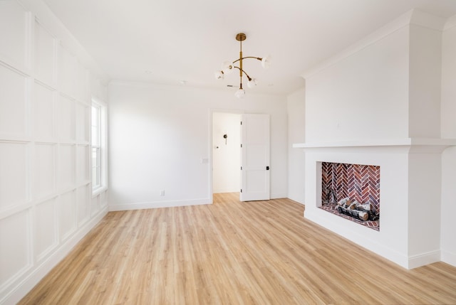 unfurnished living room with baseboards, a fireplace, light wood-style flooring, and crown molding