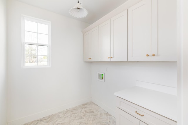 laundry area featuring washer hookup, cabinet space, and baseboards