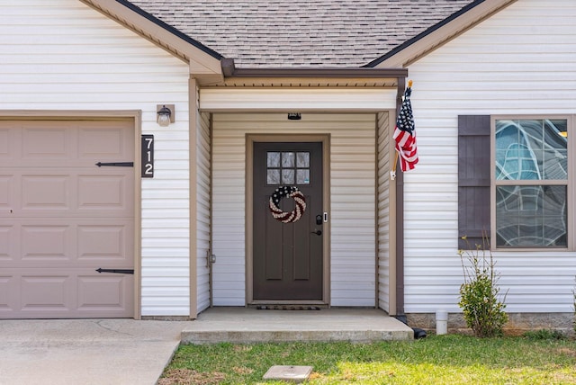 entrance to property featuring roof with shingles and an attached garage