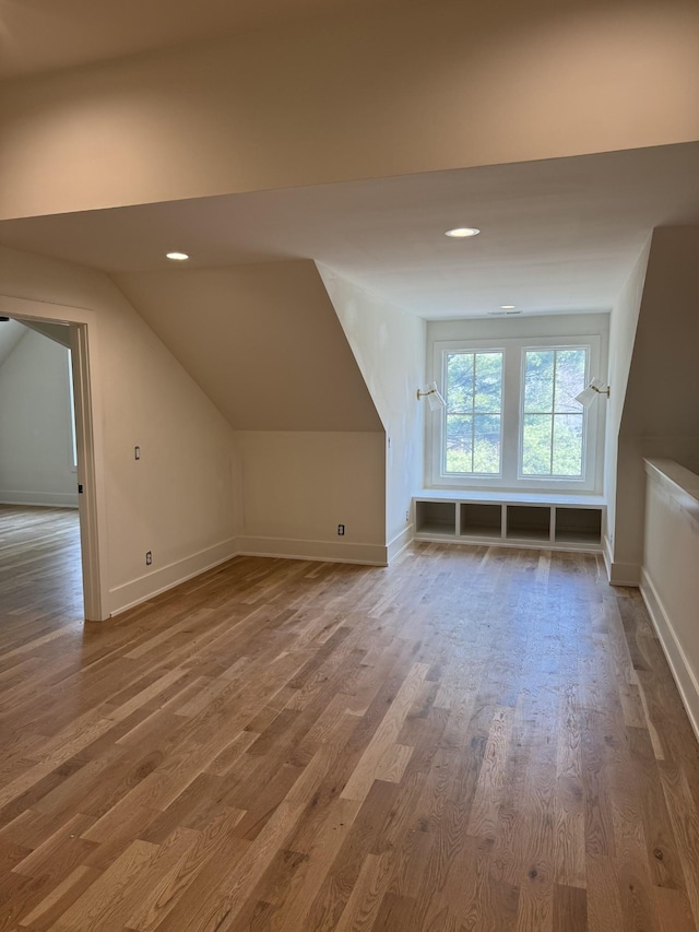 additional living space featuring vaulted ceiling, recessed lighting, wood finished floors, and baseboards